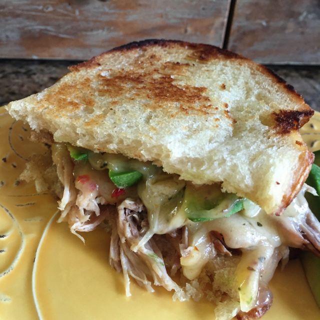 Elevated grilled cheese sandwich with pulled pork and California avocado with Cabot tomato basil cheddar.
