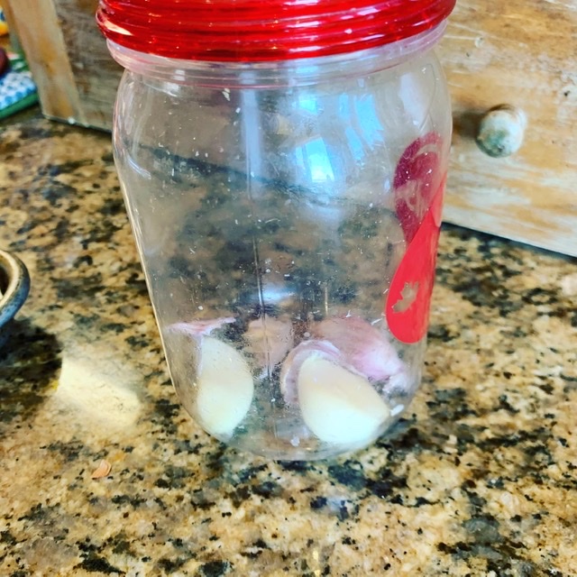 Shake garlic in a container to remove skins
